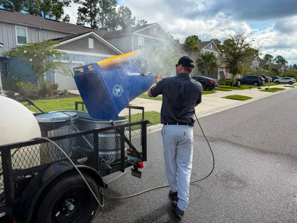 Hill Bros Bin Cleaning crew member rinsing a bin with the pressure washer