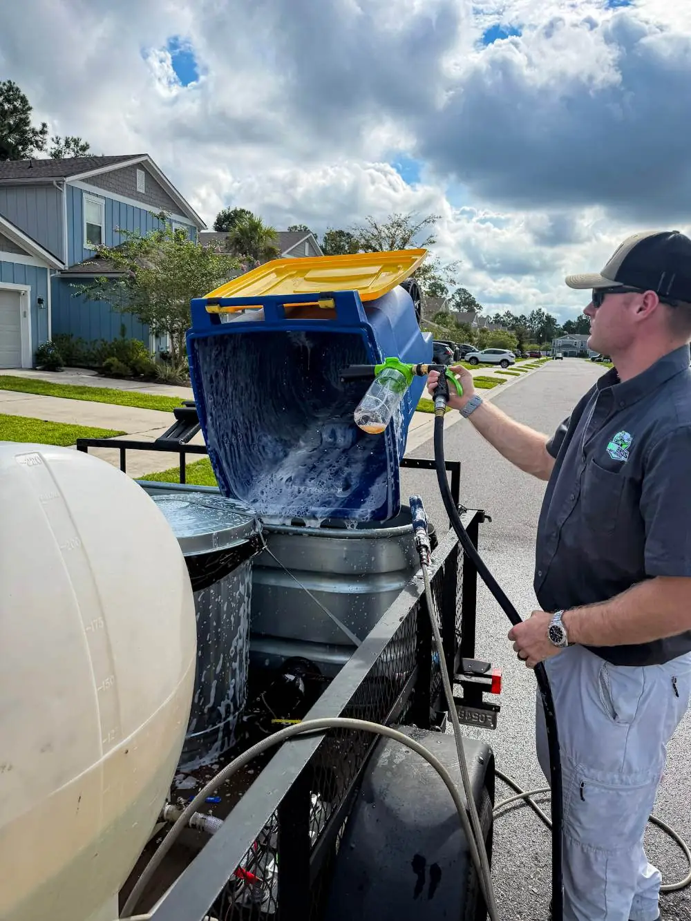 Hill Bros Bin Cleaning crew member scrubbing a bin with foaming cleaner