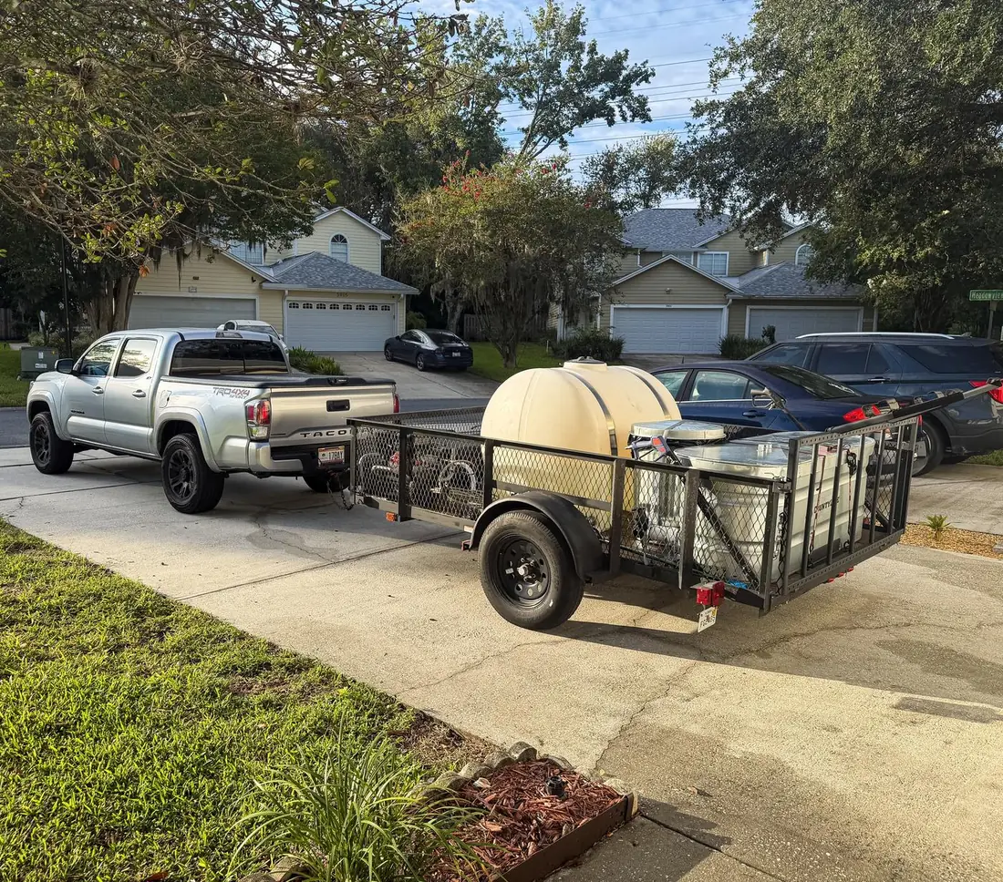 Hill Bros Bin Cleaning truck and trailer set up in a driveway, ready to clean